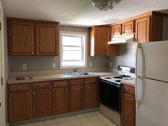 Oak kitchen cabinets, freshly painted light gray walls.