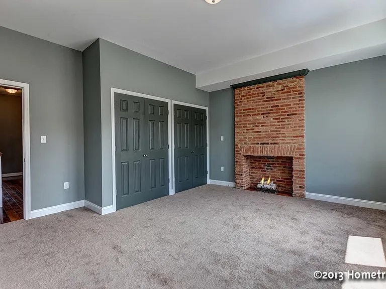 Second of two second floor bedrooms with fireplace and wall of closets