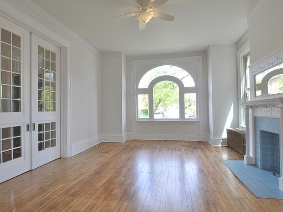 Spacious living room with French doors, hardwood floors and beautiful view of front street.