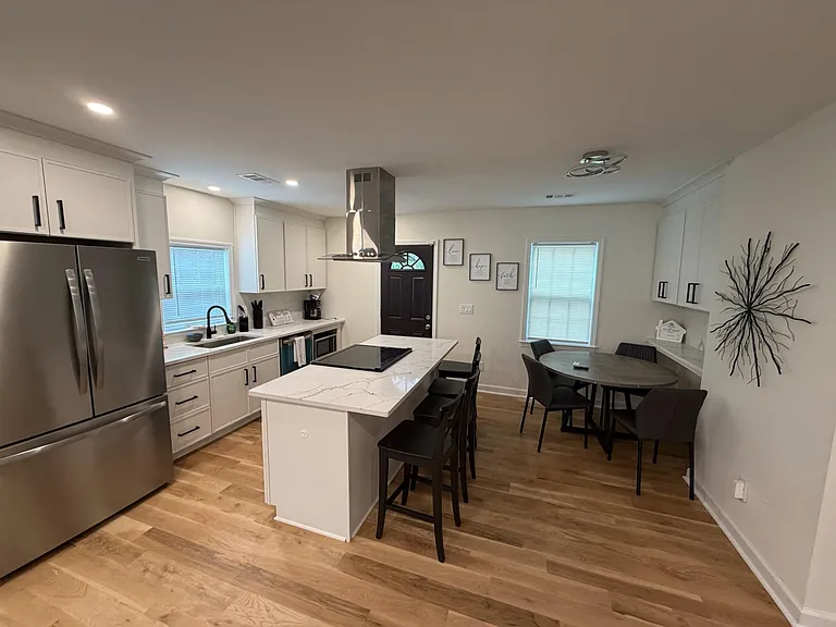 Open kitchen with a large island, stainless-steel appliances, and an adjacent dining nook for everyday meals.