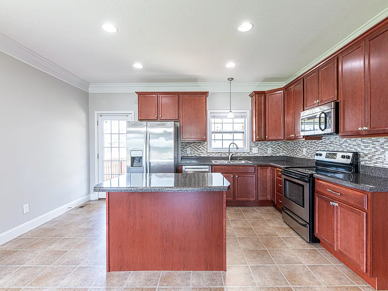 All stainless steel appliances, with touch free sink faucet and stone backsplash