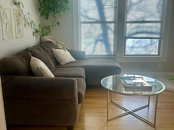 Living Room with real wood floors & large windows with mini blinds