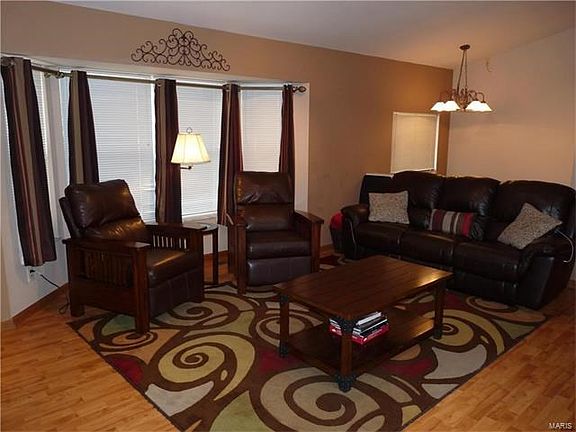 Vaulted great room with bay window & wood laminate flooring.