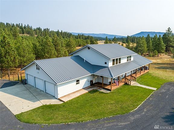 Updated farmhouse style home, with 3 car attached garage, big shop, all on 3 manageable parked out acres- WITH Southern Exposure and views of Peoh Point!