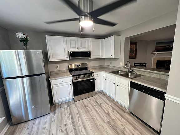 Renovated luxury vinyl kitchen flooring and new cabinets. Stainless steel stove and half-height microwave and dish washer shown