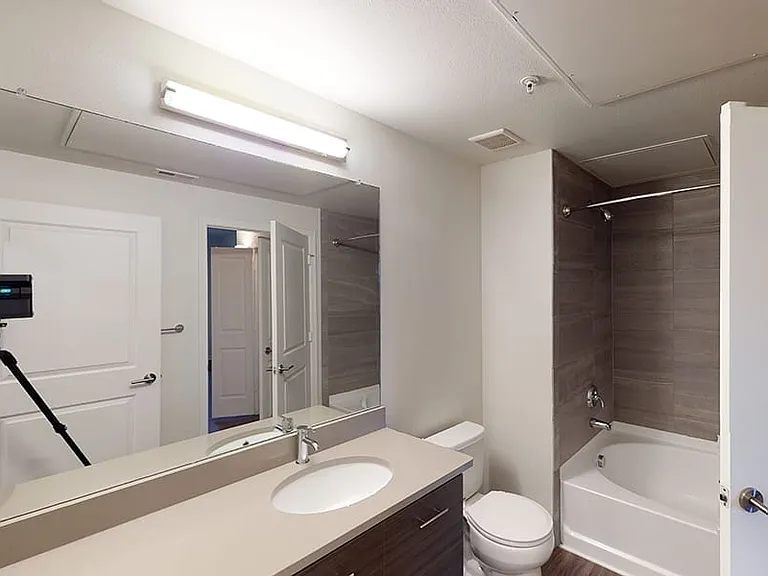 Apartment bathroom with large soaking tub and wood-style flooring.