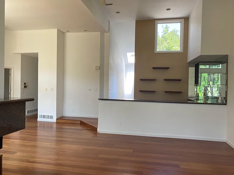 Living room and wet bar with wine refrigerator and bar sink.
