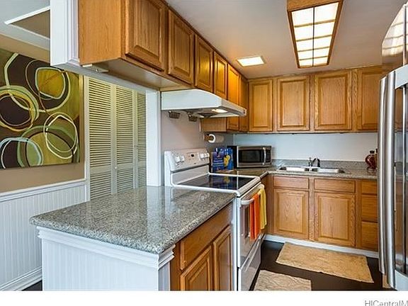 The spacious kitchen features granite countertops, newer appliances and hardwood cabinets.
