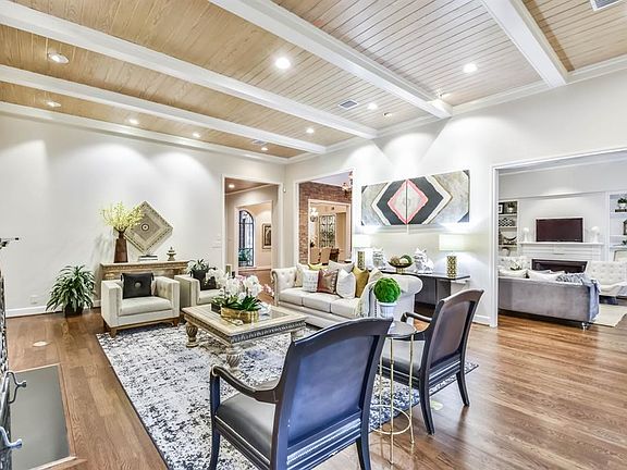Entering through the foyer, you are greeted by an expansive living room featuring a beamed bead-board ceiling and hardwoods that continue throughout the first floor.