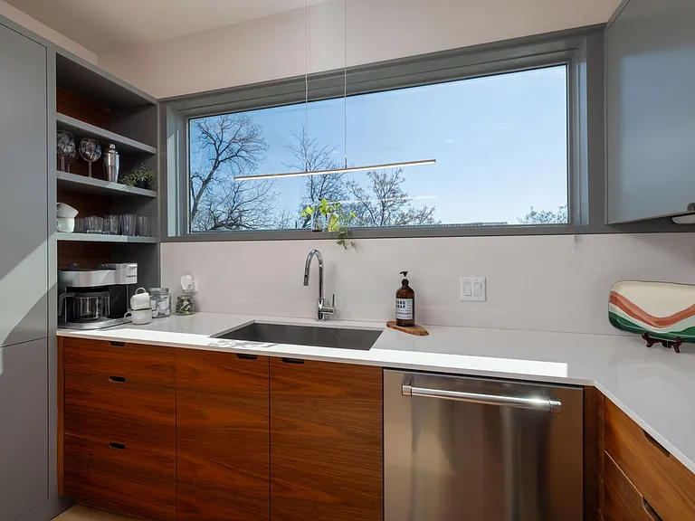Compact kitchen fully stocked with all essentials and sleek stainless steel appliances_everything you need in a cozy space.