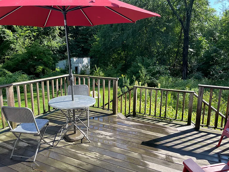 Back deck with patio table, chairs, and solar-lit umbrella.