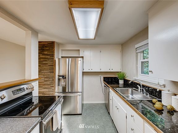 Step over to the adjoining kitchen complete with sparkling stainless steel appliances that all stay, the perfect contrast of dark granite kitchen countertops on white cabinetry, and a kitchen window overlooking your expansive backyard.