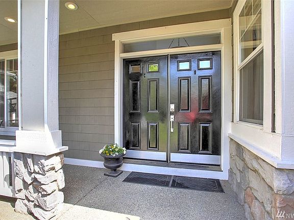 The entry is inviting with beautiful double doors and a deep front porch. Hardi-plank siding is accented by attractive stone fascia. 