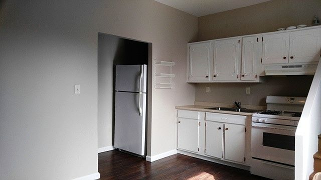 Kitchen / left where frig is are stairs to bedroom
