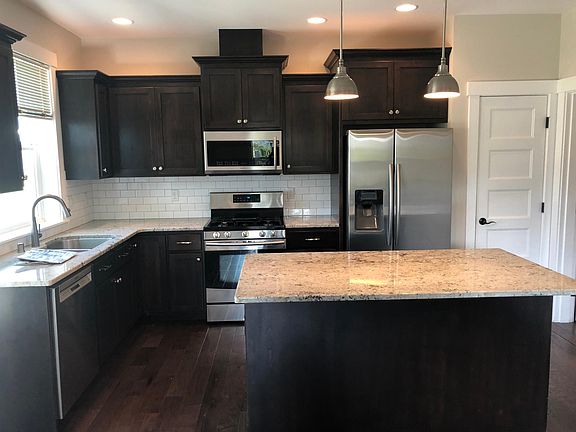 Kitchen/family room with granite countertops, island, stainless appliances and pantry
