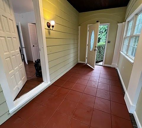 Walk through the main door to an enclosed porch with original wood ceiling and lots of windows.