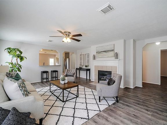 Large living area with wood laminate flooring and gaslog fireplace
