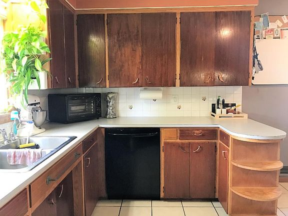 Large kitchen window over sink overlooks fenced in side yard