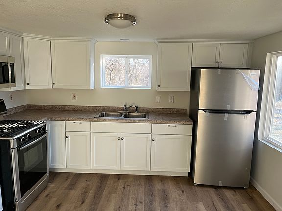Kitchen includes microwave, refrigerator and gas stove