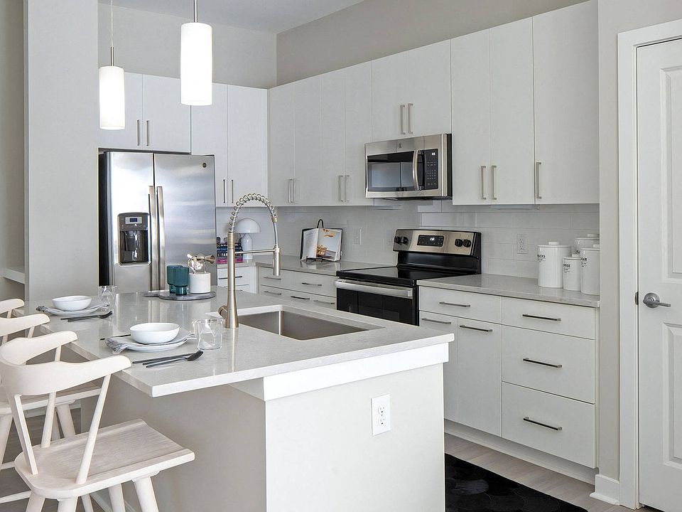 White Cabinet Kitchen Featuring Island Sink, Pendant Lights, and Built-In Microwave