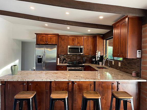 Spacious, well stocked kitchen with barstools