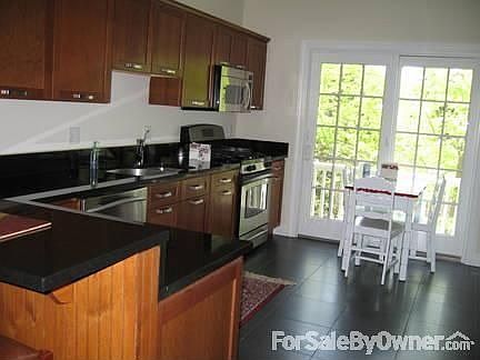 Kitchen view : cherry cabinets, porcelain tile floor, French doors to deck