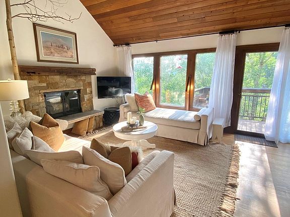 Living Room with west facing window. The entrance to the deck is straight ahead. Dining room is off to the right.