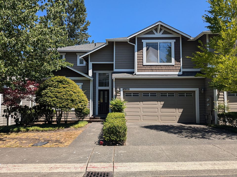 Front with two car garage and additional two parking spots