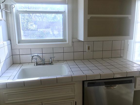 Kitchen with dishwasher, window view to backyard