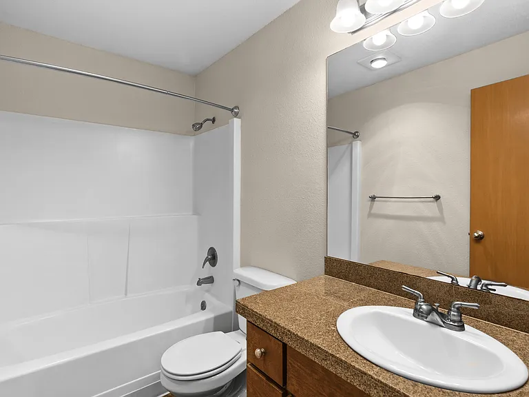 Contemporary bathroom featuring a spacious tub and shower, ample counter space, and a large vanity mirror. Contemporary bathroom featuring a spacious tub and shower, ample counter space, and a large vanity mirror.