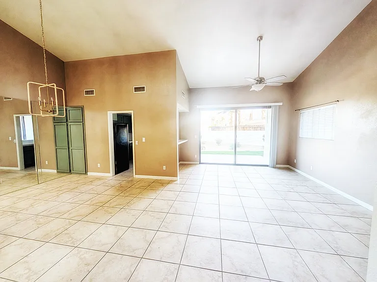 Open space living area with walk out patio featuring outdoor fan for year round comfort and relaxation.