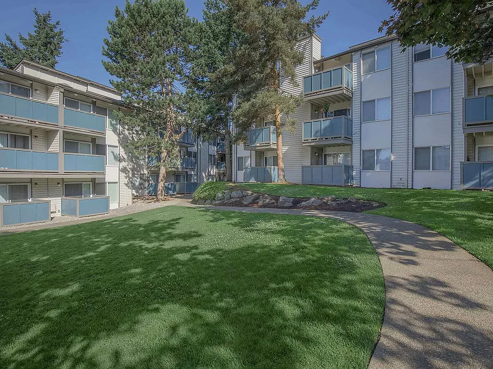 Front entrance to Foster Creek Apartments, featuring well_kept lawns, trees, and inviting residential architecture.