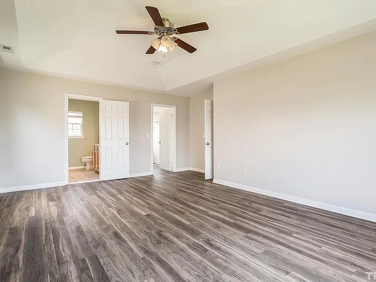 Master bedroom with bathroom and walk in closet and ceiling fan