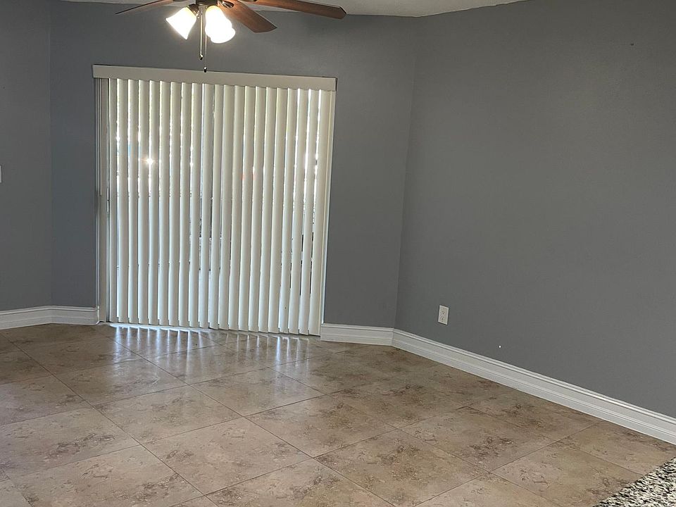 Living room and sliding glass door to outdoor screen-in lanai.