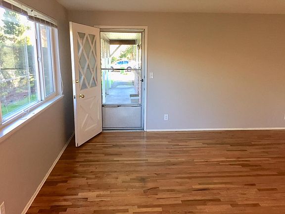 front door and living room with red oak hardwood floor