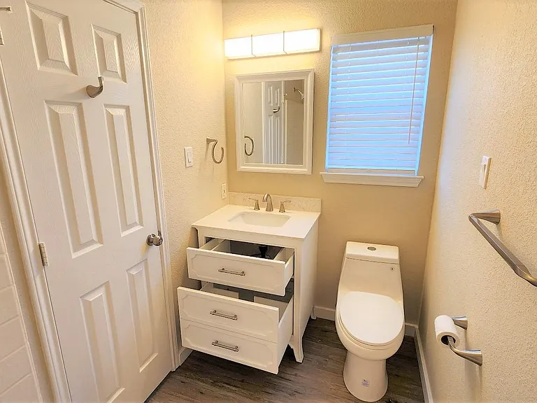 Modern bathroom features LED lighting, high-efficiency, dual-flush toilet and vanity with two draws!