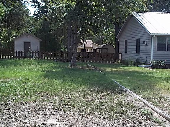 XTRA LARGE YARD WITH WOOD FENCE, FRUIT TREES AND STORAGE SHED.