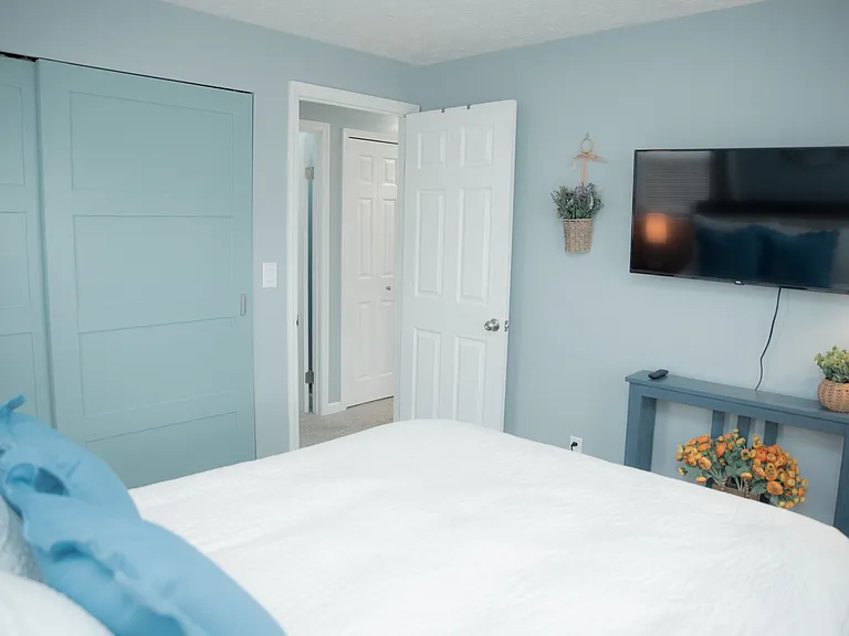 A peaceful retreat featuring a stunning botanical accent wall and a cozy queen-sized bed.