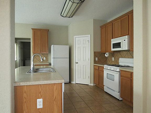 One view of kitchen, walk-in pantry, corian countertops, stove, microwave, refrigerator