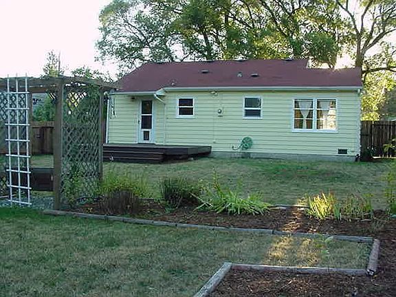 Back of home with partial view of deck