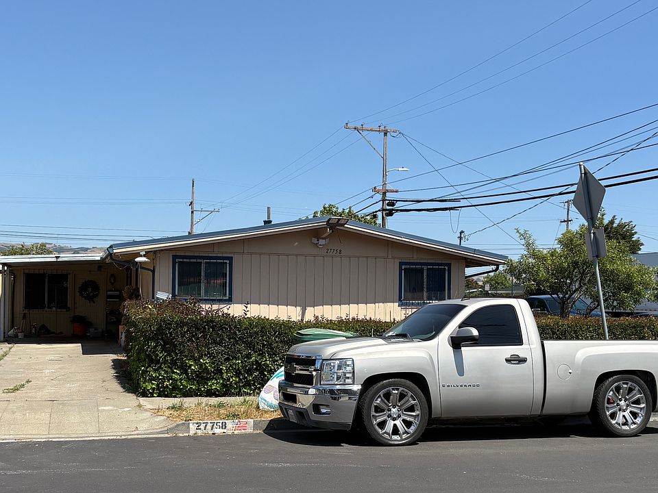 Front of house with 3-car tandem driveway, and front yard.