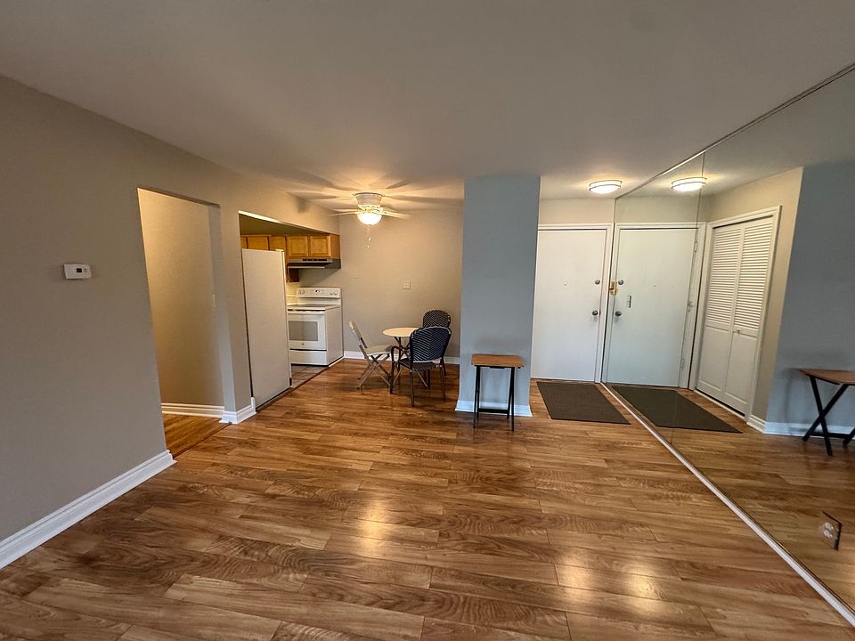 Living room looking at entry and dining nook with mirrored wall.