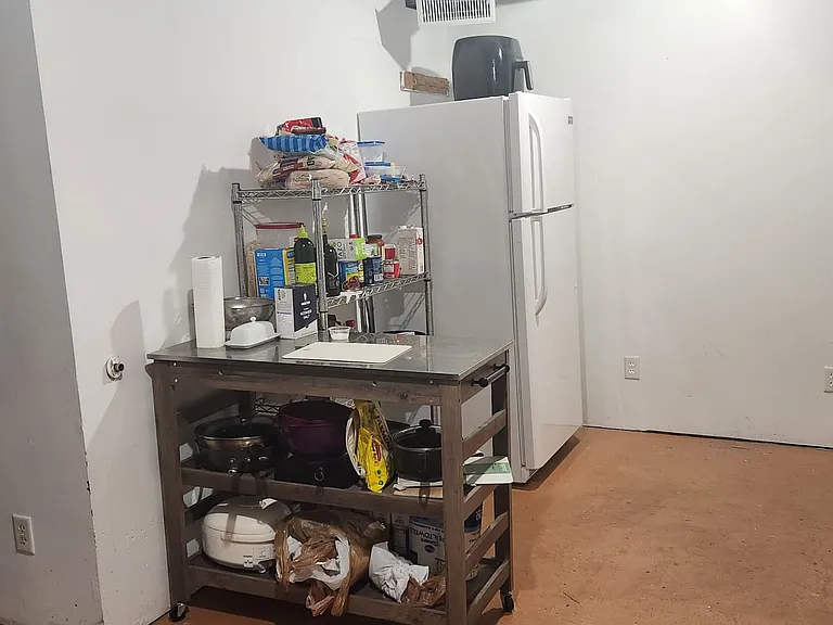 Apartment laundry/kitchen with view of fridge
