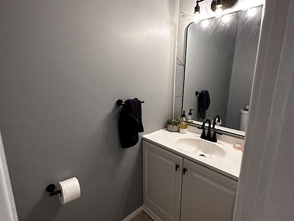 Renovated bathroom featuring matte black fixtures and marbled accent wall