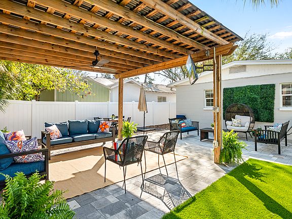 Outdoor Pergola with lots of seating, dining, and outdoor TV for entertainment