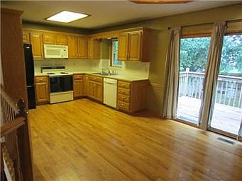 Spacious kitchen with gleaming hardwood floors.