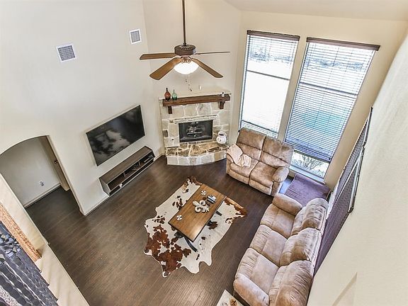Soaring ceilings in the great room surrounding a stone fireplace.