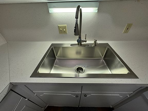 New stainless steel sink with faucet with spray spout.