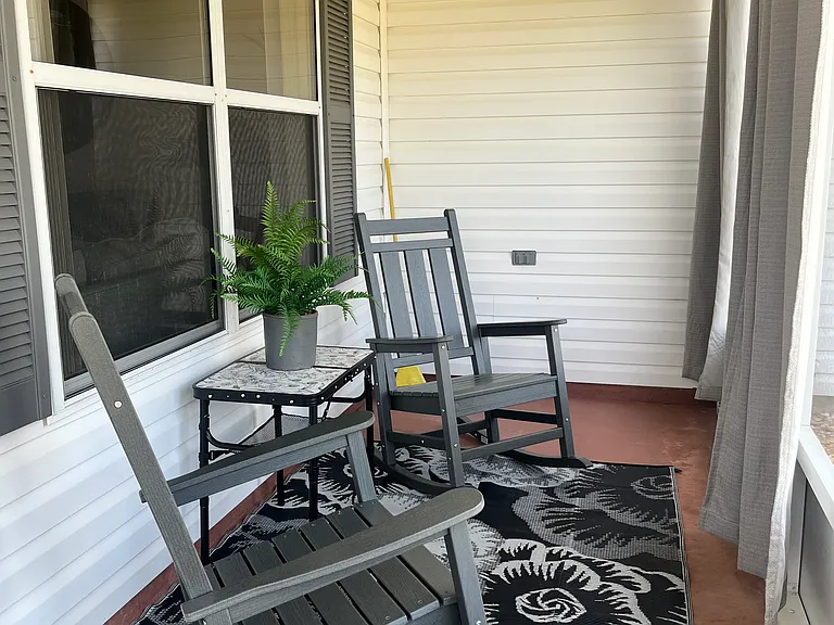 Screened front lanai with 2 all weather rockers and snack table. Curtains for privacy