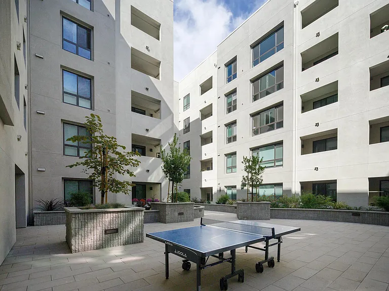 Active courtyard with a ping_pong table, open seating, and greenery creating a welcoming spot for casual fun.